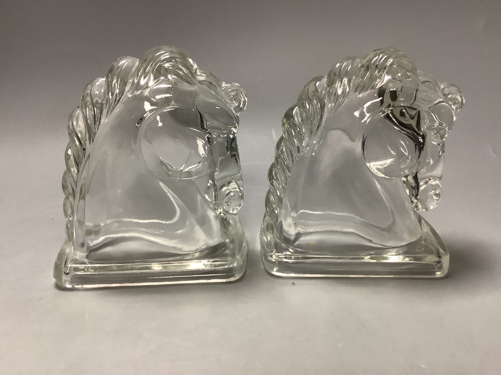 A pair of American press moulded glass horse head bookends, height 14cm